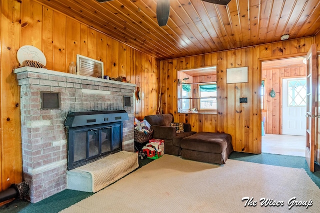 1261 W Channel St, Bitely, MI 49309 - living area featuring wood walls, a fireplace, wooden ceiling, carpet floors, and a ceiling fan