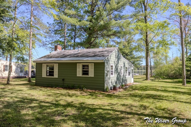 1261 W Channel St, Bitely, MI 49309 - view of side of property with a chimney and a lawn