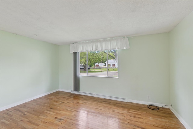 530 Manitou Rd, Saint Joseph, MI 49085 - empty room featuring wood finished floors, a textured ceiling, a baseboard radiator, and baseboards