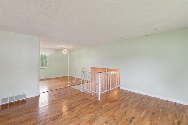 530 Manitou Rd, Saint Joseph, MI 49085 - spare room with wood finished floors, a chandelier, baseboards, and a textured ceiling