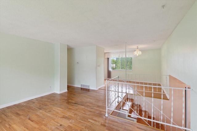 530 Manitou Rd, Saint Joseph, MI 49085 - unfurnished room featuring wood finished floors, a chandelier, and baseboards