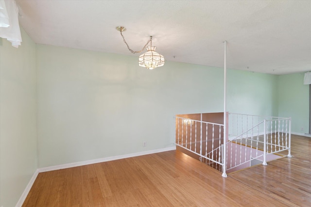 530 Manitou Rd, Saint Joseph, MI 49085 - unfurnished room featuring wood finished floors, a chandelier, and baseboards
