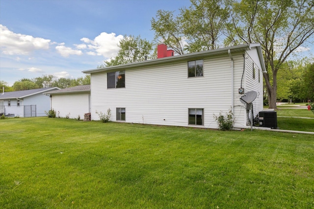 530 Manitou Rd, Saint Joseph, MI 49085 - rear view of house with central AC unit, a lawn, and a chimney