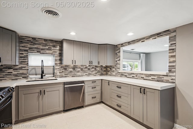 11651 Mason Rd, Webberville, MI 48892 - kitchen with stainless steel dishwasher, gray cabinets, a sink, black gas range oven, and decorative backsplash