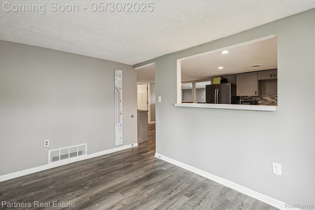 11651 Mason Rd, Webberville, MI 48892 - unfurnished living room featuring wood finished floors, baseboards, recessed lighting, and a textured ceiling