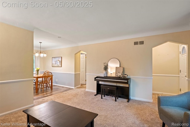 22810 Lilac St, Farmington, MI 48336 - carpeted living area with a chandelier, arched walkways, and baseboards