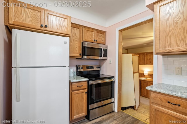 22810 Lilac St, Farmington, MI 48336 - kitchen with stainless steel appliances, tasteful backsplash, light stone countertops, and light wood-style flooring