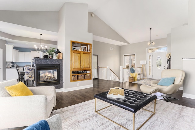 9077 24th Ave, Jenison, MI 49428 - living area featuring high vaulted ceiling, a chandelier, dark wood-type flooring, and baseboards
