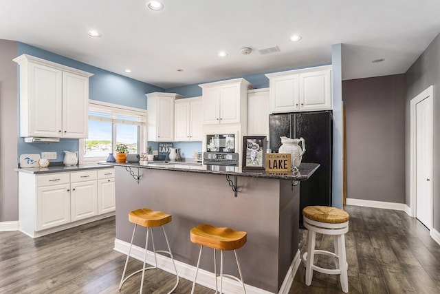 9077 24th Ave, Jenison, MI 49428 - kitchen featuring freestanding refrigerator, a kitchen breakfast bar, white cabinetry, baseboards, and recessed lighting