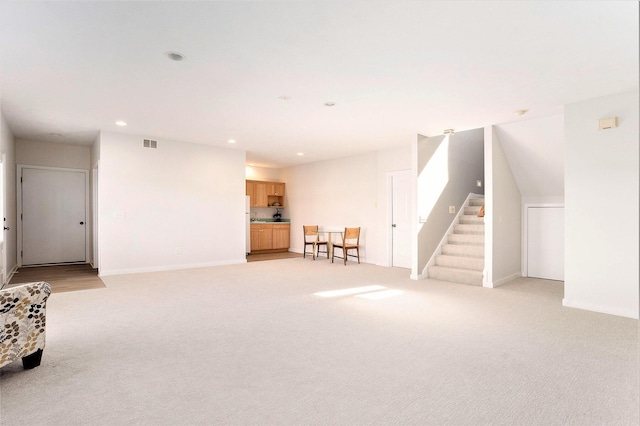 9077 24th Ave, Jenison, MI 49428 - unfurnished living room featuring light colored carpet, recessed lighting, stairway, and baseboards