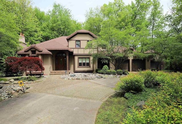 10466 W Farrand Rd, Montrose, MI 48457 - view of front of home featuring stucco siding, decorative driveway, and a chimney