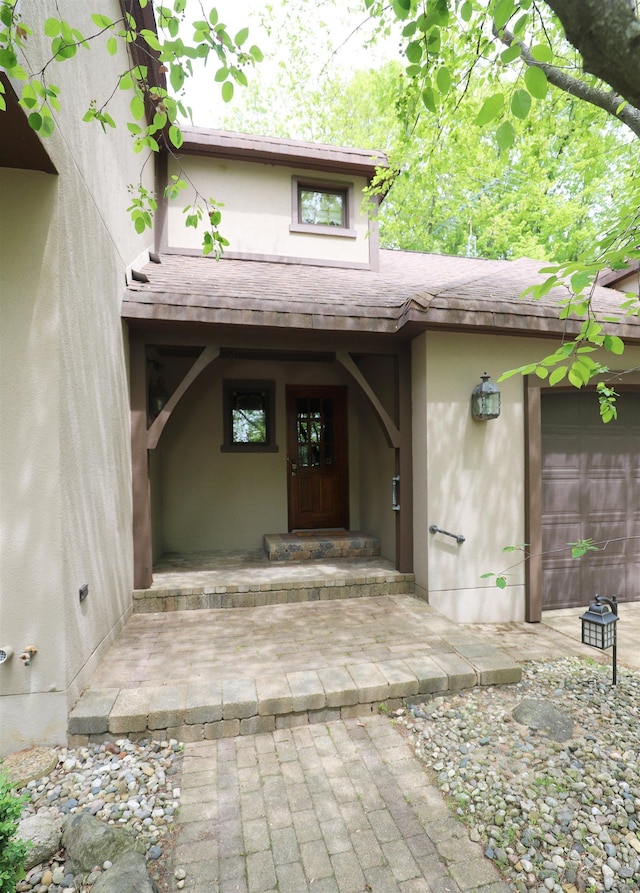 10466 W Farrand Rd, Montrose, MI 48457 - entrance to property featuring stucco siding, a shingled roof, and a garage