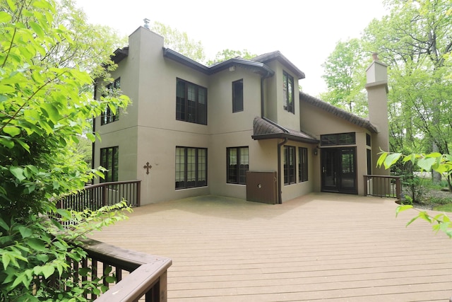 10466 W Farrand Rd, Montrose, MI 48457 - back of property with a deck, stucco siding, and a chimney