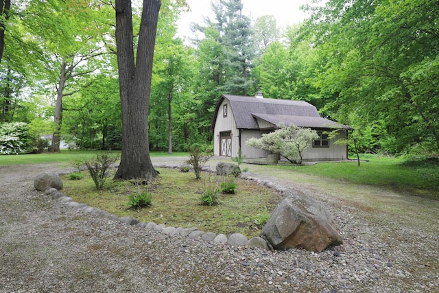 10466 W Farrand Rd, Montrose, MI 48457 - view of front of house featuring dirt driveway, a gambrel roof, a chimney, a shingled roof, and an outbuilding