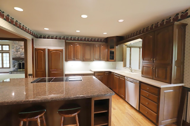 10466 W Farrand Rd, Montrose, MI 48457 - kitchen with stainless steel dishwasher, paneled refrigerator, a sink, black electric cooktop, and glass insert cabinets