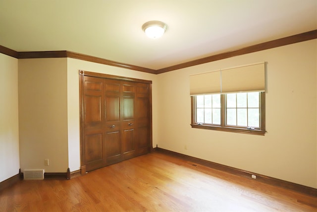 10466 W Farrand Rd, Montrose, MI 48457 - unfurnished bedroom with wood finished floors, a closet, baseboards, and ornamental molding