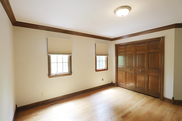 10466 W Farrand Rd, Montrose, MI 48457 - unfurnished bedroom with multiple windows, crown molding, light wood-type flooring, and baseboards