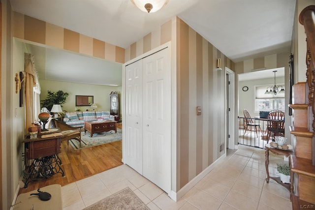 39582 Tunstall St, Clinton Township, MI 48038 - corridor featuring wallpapered walls, light tile patterned floors, a chandelier, and baseboards