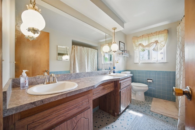 39582 Tunstall St, Clinton Township, MI 48038 - full bathroom featuring tile walls, double vanity, wainscoting, and toilet