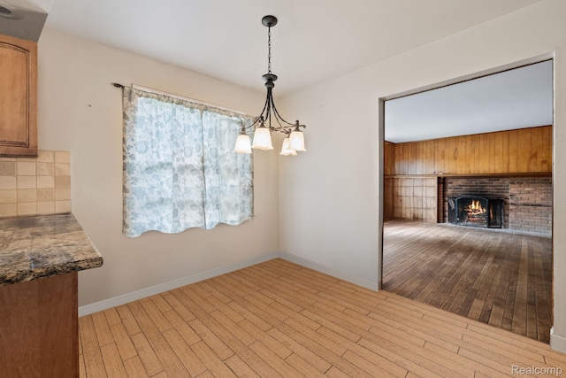 4603 Hedgewood, Bloomfield Hills, MI 48301 - unfurnished dining area with wood finished floors, a chandelier, a brick fireplace, and baseboards