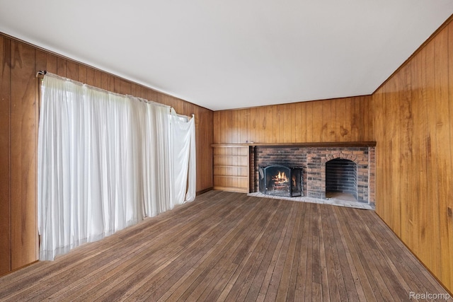 4603 Hedgewood, Bloomfield Hills, MI 48301 - unfurnished living room featuring wooden walls, a brick fireplace, and dark wood-style flooring