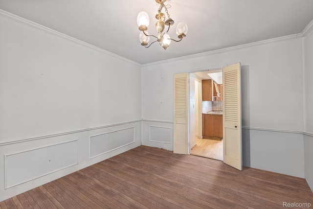 4603 Hedgewood, Bloomfield Hills, MI 48301 - spare room featuring a chandelier, ornamental molding, hardwood / wood-style floors, and wainscoting