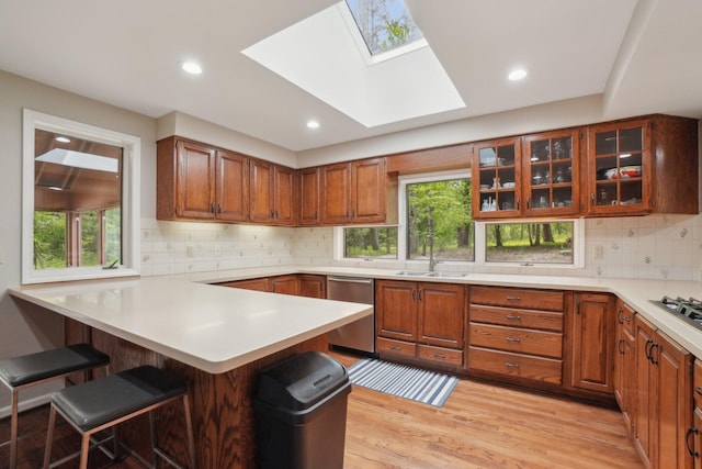 3805 Penberton Ct, Ann Arbor, MI 48105 - kitchen featuring appliances with stainless steel finishes, a sink, a peninsula, a breakfast bar, and a skylight