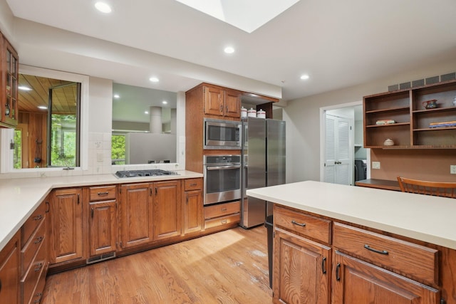 3805 Penberton Ct, Ann Arbor, MI 48105 - kitchen with appliances with stainless steel finishes, open shelves, light wood-type flooring, brown cabinetry, and backsplash