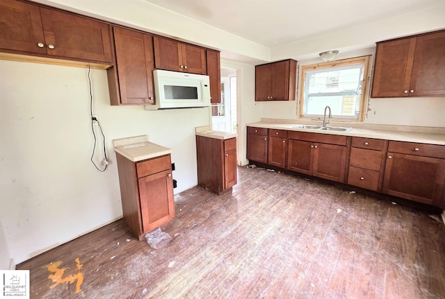 3416 Willard Rd, Birch Run, MI 48415 - kitchen featuring white microwave, wood finished floors, light countertops, and brown cabinets