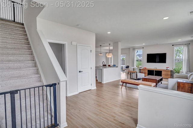 8811 Pioneer St, Washington, MI 48094 - living room featuring light wood-style floors, recessed lighting, stairs, and baseboards