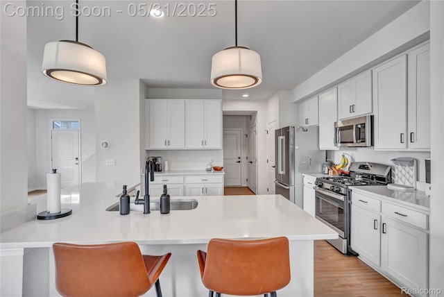 8811 Pioneer St, Washington, MI 48094 - kitchen with stainless steel appliances, a breakfast bar, a sink, white cabinetry, and light countertops