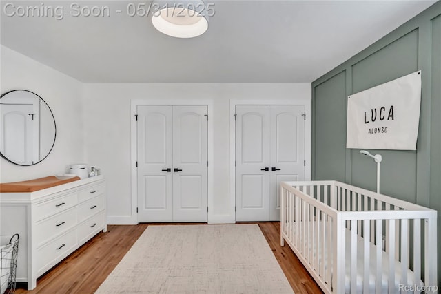 8811 Pioneer St, Washington, MI 48094 - bedroom with multiple closets, wood finished floors, and a nursery area