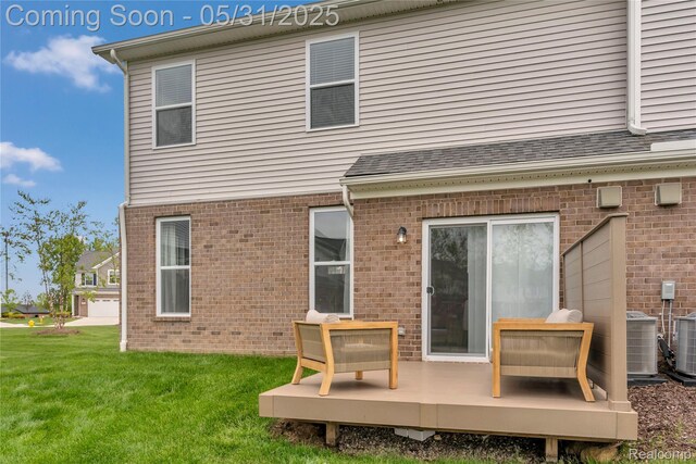 8811 Pioneer St, Washington, MI 48094 - back of property featuring brick siding, a yard, a deck, and central air condition unit