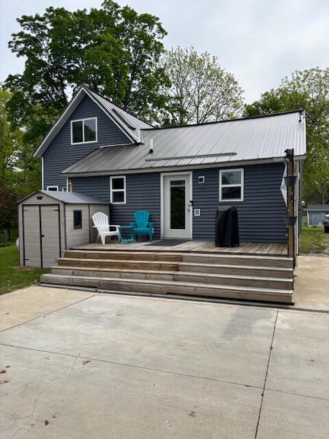 209 S Lake Ave, Fremont, MI 49412 - rear view of property with a deck, metal roof, and a patio area