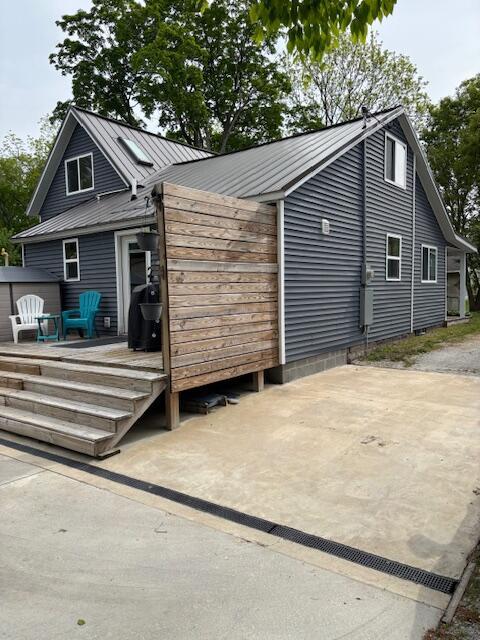 209 S Lake Ave, Fremont, MI 49412 - view of home's exterior with a wooden deck and metal roof