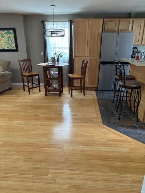 209 S Lake Ave, Fremont, MI 49412 - dining space featuring wood finished floors, a chandelier, and baseboards