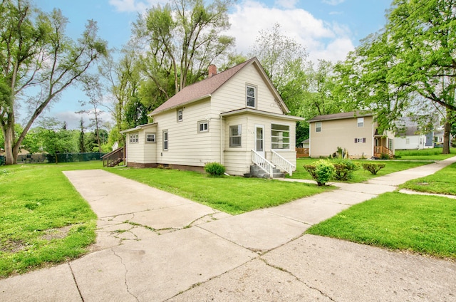 157 E Mansion St, Jackson, MI 49203 - view of front facade with a chimney, concrete driveway, a front lawn, and entry steps