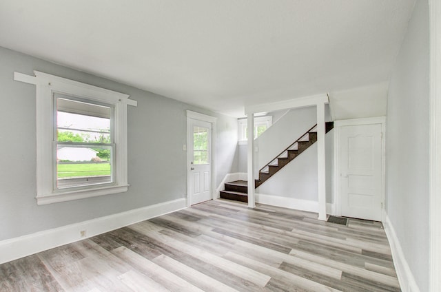 157 E Mansion St, Jackson, MI 49203 - unfurnished room featuring stairs, light wood-type flooring, and baseboards
