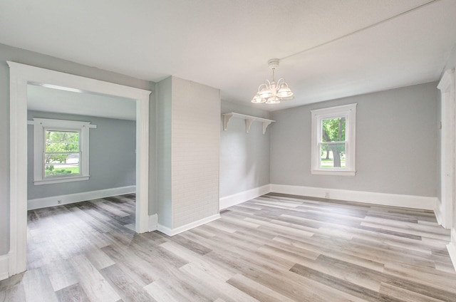 157 E Mansion St, Jackson, MI 49203 - unfurnished room featuring a chandelier, baseboards, and light wood finished floors