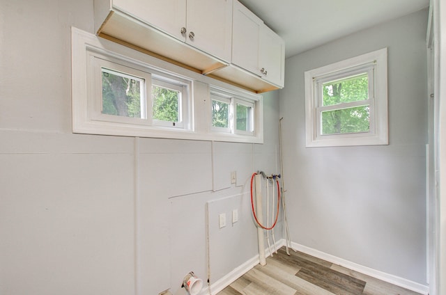157 E Mansion St, Jackson, MI 49203 - laundry area featuring light wood-type flooring, baseboards, cabinet space, and washer hookup