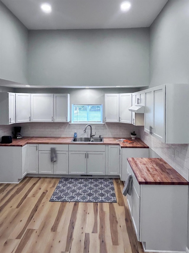 5098 N Center Rd, Flint, MI 48506 - kitchen featuring wooden counters, a sink, light wood-type flooring, decorative backsplash, and recessed lighting