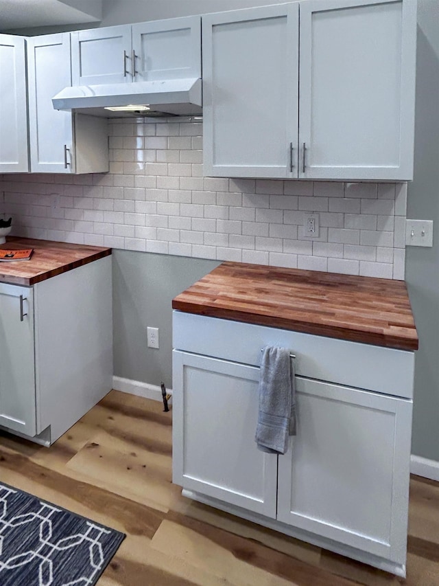 5098 N Center Rd, Flint, MI 48506 - kitchen featuring butcher block counters, decorative backsplash, light wood-style floors, and under cabinet range hood