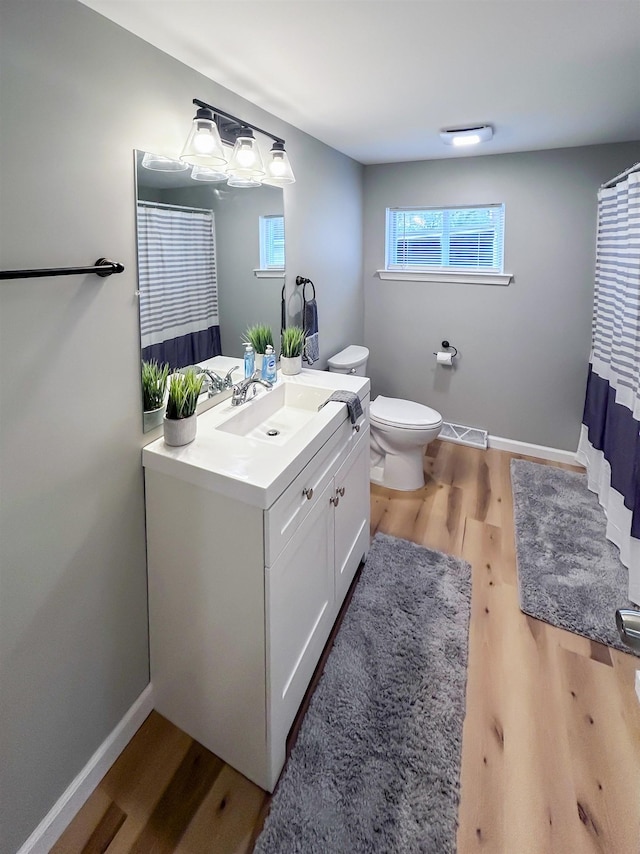 5098 N Center Rd, Flint, MI 48506 - full bathroom featuring vanity, toilet, wood finished floors, and baseboards