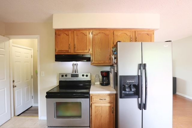 1029 N Linden Rd, Flint, MI 48532 - kitchen featuring appliances with stainless steel finishes, under cabinet range hood, light countertops, baseboards, and brown cabinetry