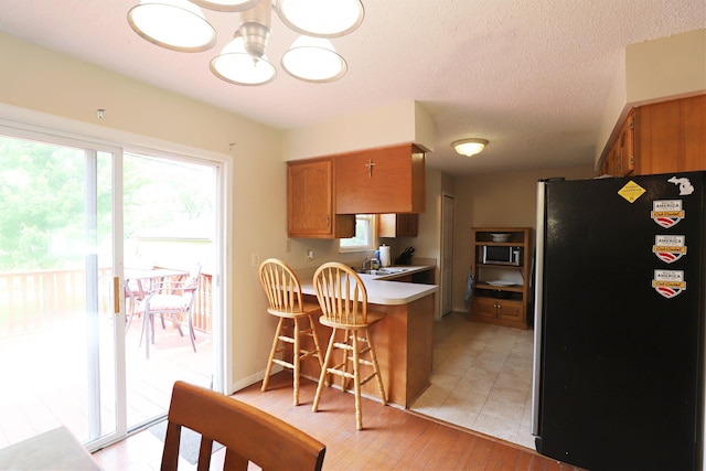 1029 N Linden Rd, Flint, MI 48532 - kitchen with stainless steel appliances, a peninsula, plenty of natural light, and brown cabinets
