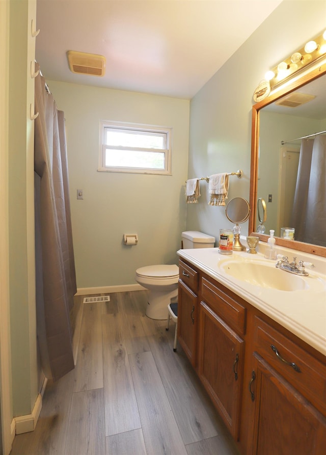 1029 N Linden Rd, Flint, MI 48532 - full bath with vanity, toilet, wood finished floors, a shower with shower curtain, and baseboards