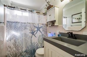 1760 Cole St, Birmingham, MI 48009 - bathroom with toilet, vanity, and curtained shower