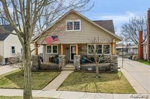 1760 Cole St, Birmingham, MI 48009 - bungalow-style house featuring covered porch, a front lawn, and driveway