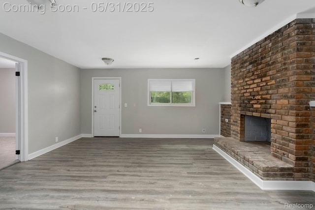 16565 Winston St, Detroit, MI 48219 - unfurnished living room with baseboards, wood finished floors, and a brick fireplace