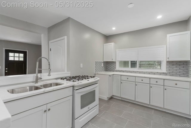 16565 Winston St, Detroit, MI 48219 - kitchen with a sink, white range with gas stovetop, white cabinets, decorative backsplash, and recessed lighting